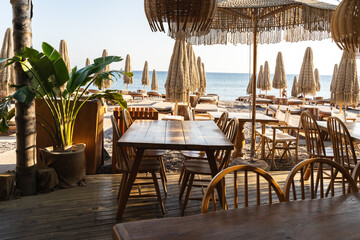 Tables in a cozy beach cafe in Greece early in the morning before opening without visitors