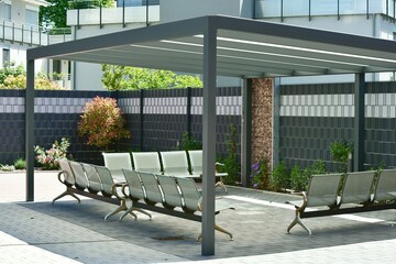 Zentraler Terrassenbereich mit Metallständer-Milchglasdach eingebauten Metallsitzen optischer...