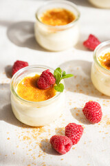 French dessert custard creme brulee with caramel crust, garnished with fresh berries. Traditional cuisine. Vertical photo