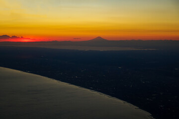 空から見た夕焼けの中の富士山