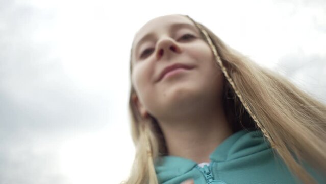 A close-up of the zipper of the sweater. A girl fastens her jacket with her fingers on the street. High quality 4k footage
