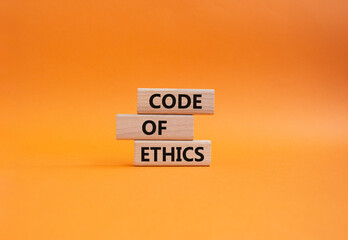 Code of ethics symbol. Concept words Code of ethics on wooden blocks. Beautiful orange background. Business and Code of ethics concept. Copy space.