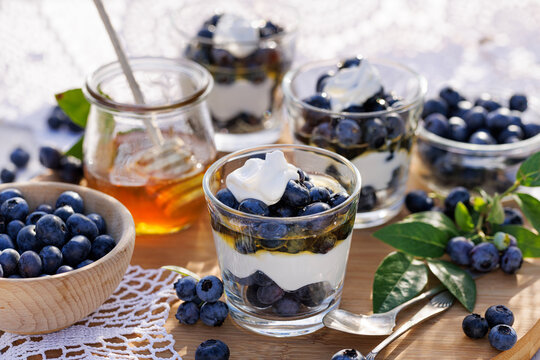 Dessert of blueberries and natural yoghurt with addition honey, close-up.  Healthy and delicious breakfast