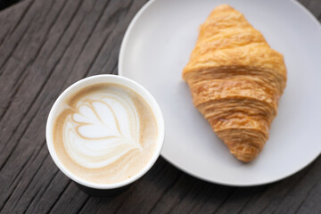 Fresh delicious breakfast morning with Coffee, food croissants on brunch plate, jam on dark grunge wooden background. continental breakfast captured on above table top view flat lay.