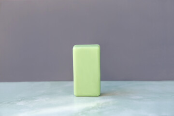 Green cleansing bar soap on gray wall background