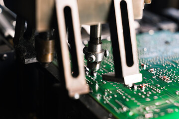 SMD surface-mount device working on printed circuit board PCB mounting electrical components. Modern precision technology. Horizontal close-up shot. High quality photo
