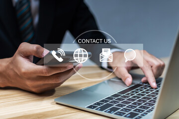 Contact us. business people hand using laptop computer with virtual graphic icon diagram on desk at office, digital marketing, work from home, business finance, internet network technology concept
