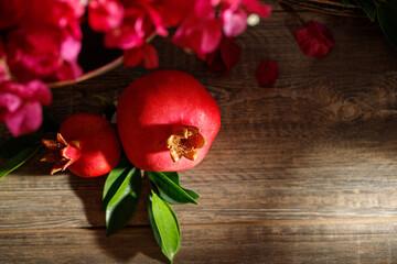 Pomegranates on a wooden table, the symbol of the Jewish new year - Rosh Hashanah. Dark background