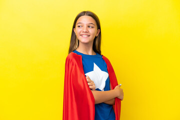 Little caucasian superhero girl isolated on yellow background happy and smiling
