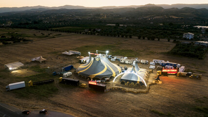 Big top of a circus with caravans in a field