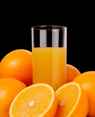 Orange juice glass on orange juice fruits on black background.