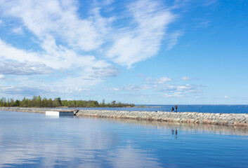 Men fishing on stone shore on Ladoga lake on sunny day