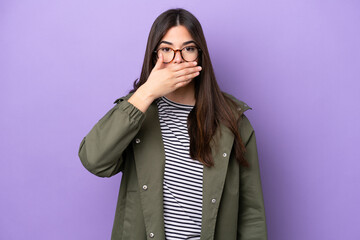 Young Brazilian woman isolated on purple background covering mouth with hand