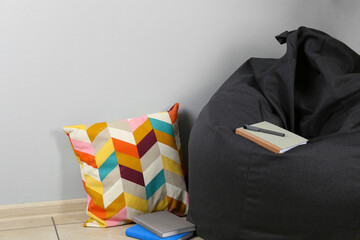 Black cozy bean bag chair near light grey wall in room