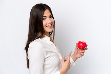 Young Brazilian woman with an apple isolated on white background and pointing it