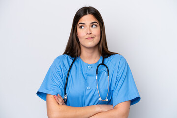 Young Brazilian nurse woman isolated on white background making doubts gesture while lifting the...