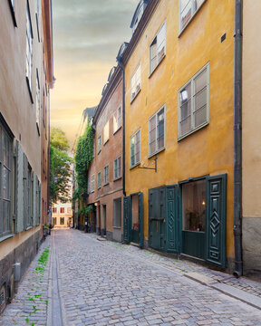 Narrow alley in Gamla stan, the old town of Stockholm, Sweden, with old style orange colored houses and cobblestone street, Stockholm, Sweden