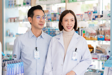 Portrait of two confident asian pharmacist standing in pharmacy drugstore. Drug store owner working with teamwork.