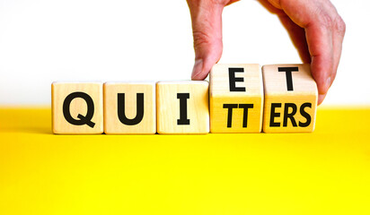 Quiet quitters symbol. Concept words Quiet quitters on wooden cubes. Businessman hand. Beautiful yellow table white background. Business quiet quitters concept. Copy space.