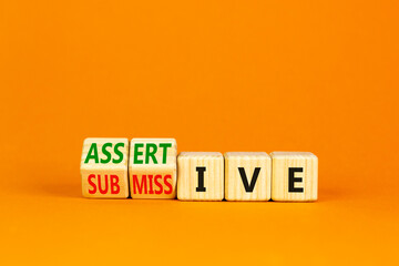 Submissive or assertive symbol. Concept words Submissive and assertive on wooden cubes. Beautiful...