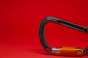 Lightweight versatile carabiner for climbing and mountaineering on a red background