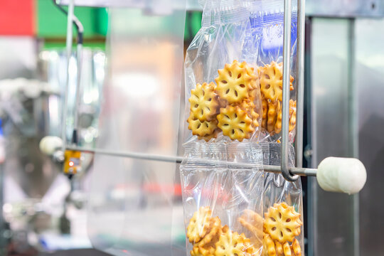 Close up sandwich cookies biscuits with pineapple jam after process fill to plastic pouch bag and seal by continuous vertical automatic packing machine for industrial