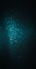 Particles texture background. Bokeh light flare. Blur glitter. Defocused blue green color sparkles on dark night black abstract poster.