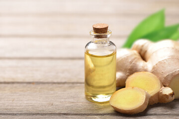 Obraz na płótnie Canvas Ginger essential oil extract rhizome on wooden table.