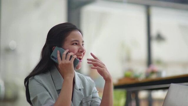 Young business women working and talking on a phone calling with happy and smile face on office space.