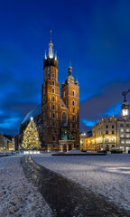 St Mary's church on snow covered Main Square in winter Krakow, illuminated in the night.