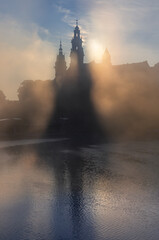 Beautiful foggy sunrise with Wawel castle over Vistula river, Krakow, Poland