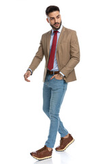 bearded guy with red tie holding hand in pocket and looking away