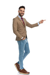 excited cool man with beard pointing finger to side and smiling