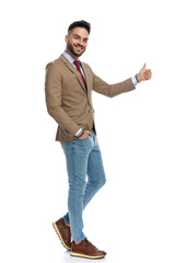 happy guy making thumbs up gesture while smiling and walking