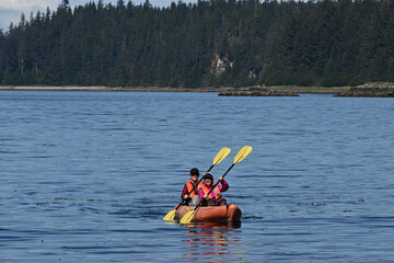 Friends kayaking together in tandem kayak.