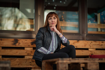 Portrait of a young beautiful red-haired girl in a spring park. There is artistic noise.