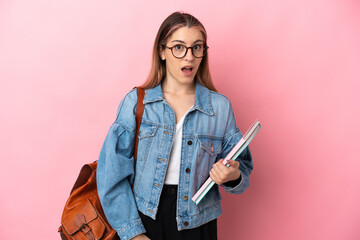 Young caucasian student woman isolated on pink background with surprise facial expression