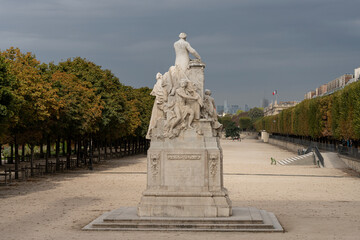 Paris, France - 09 16 2021: Tuileries garden. View of sculpture of Jules ferry in the park and La Defense buildings behind