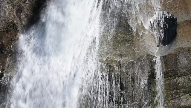 Waterfall closeup with stone created pothole.