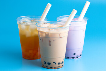 Three Different Types of Boba Tea on a Bright Blue Background