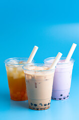 Three Different Types of Boba Tea on a Bright Blue Background