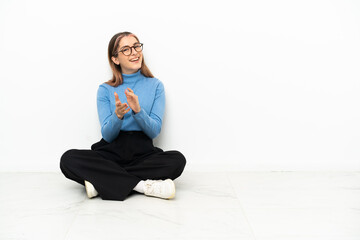 Young Caucasian woman sitting on the floor applauding after presentation in a conference