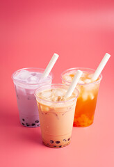 Three Different Types of Boba Tea on a Bright Pink Background