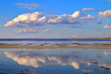Reflecting clouds over the mirror surface of a salty shallow estuary.