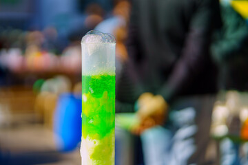 Chemical beaker with green liquid and plenty of foam
