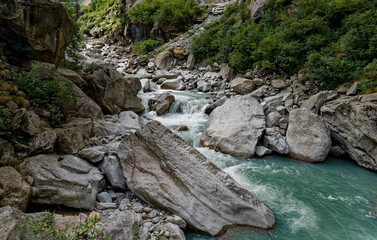 Obraz premium Creek or stream water flowing past rocks and stones