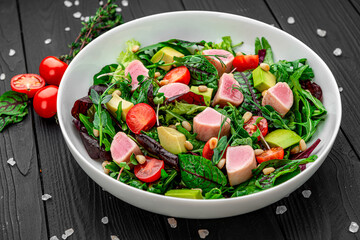 Japanese traditional salad with pieces of medium-rare grilled Ahi tuna and sesame with fresh vegetable on a bowl.