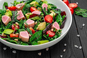 Japanese traditional salad with pieces of medium-rare grilled Ahi tuna and sesame with fresh vegetable on a bowl.