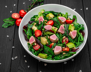 Japanese traditional salad with pieces of medium-rare grilled Ahi tuna and sesame with fresh vegetable on a bowl.