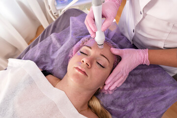 Beautiful woman getting face vacuum procedure for healthy skin in spa salon. 